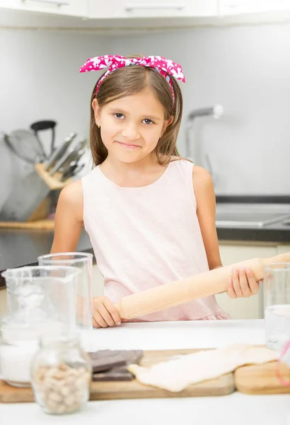 Portrait of cute smiling girl with rolling pin making dough — Stock Photo, Image