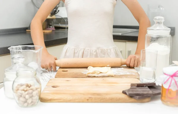 Primo piano colpo di ragazza rotolamento pasta con perno di legno sulla cucina — Foto Stock
