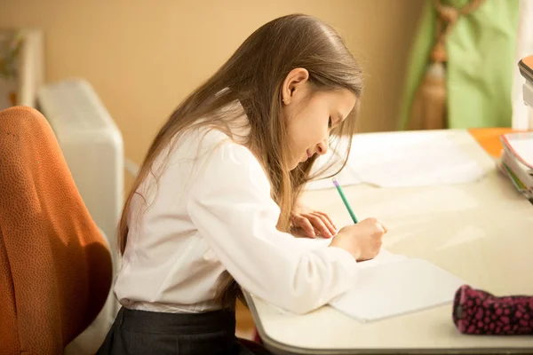写在笔记本上用铅笔在她的卧室里的女孩 — 图库照片