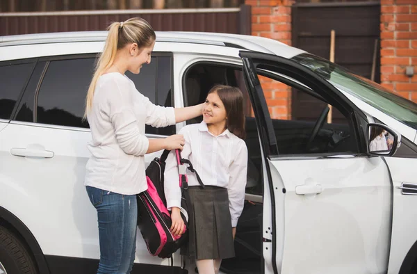 Mooie jonge moeder helpt dochter om uit de auto en pu — Stockfoto