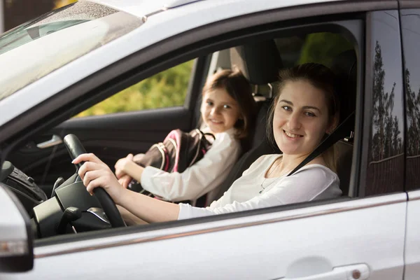 Portrait of smiling mother taking her daughter to school by car — Stock Photo, Image