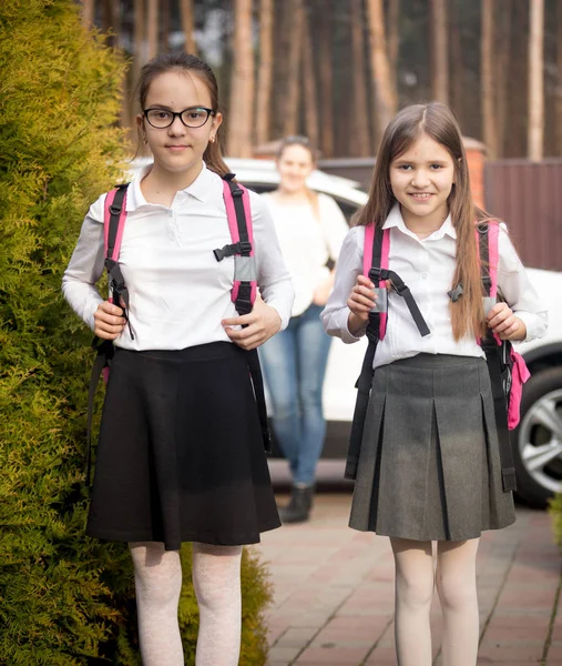 Porträtt av två glada flickor gå i skolan på morgonen — Stockfoto