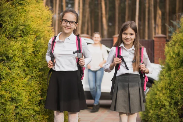Två tjejer poserar med skolväskor efter lektion i skolan — Stockfoto