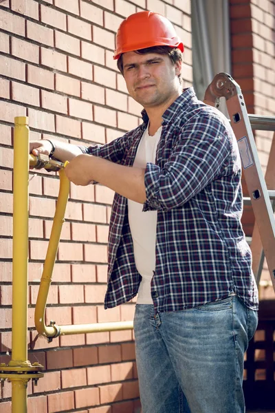 Portret van lachende loodgieter repareren van leidingen — Stockfoto