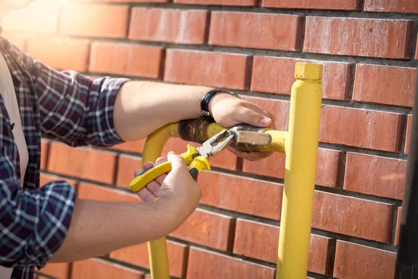 Closeup of engineer repairing valve on yellow gas pipe — Stock Photo, Image