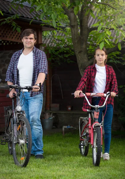 Jeune homme et adolescente posant avec des vélos — Photo