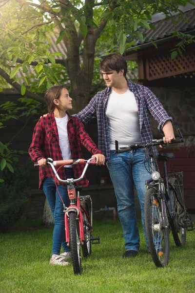 快乐的年轻男人和小女孩微笑着摆了自行车 — 图库照片