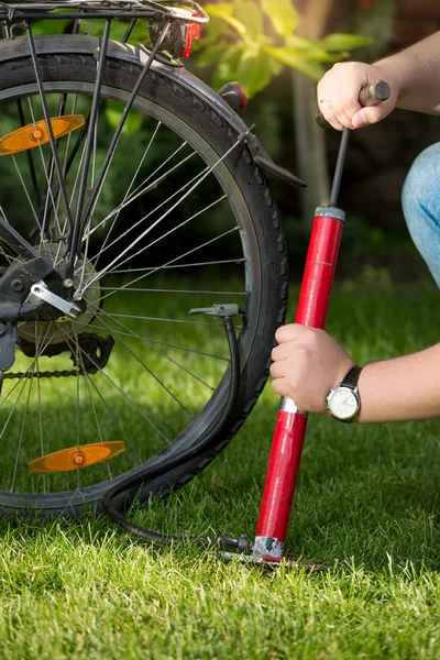 Vértes fiatalember, szivattyúzás a kerékpár gumiabroncs — Stock Fotó