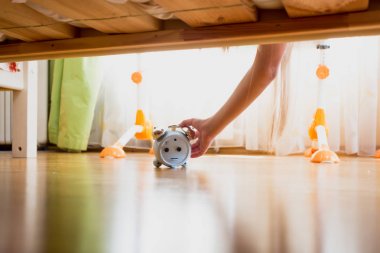 Yatağın altına ulaşan ve alarm Erteleme düğmesine basarak kadın