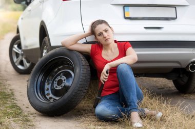 Kırık araba, zeminde siting ve yedek ty eğilerek üzgün kadın