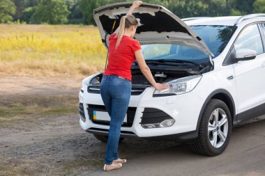 Genç kadın kırsal Brokedown araba tamir etmeye çalıştığını