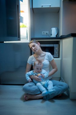 Mutfak bebek oğluyla birlikte oturan genç uykulu anne