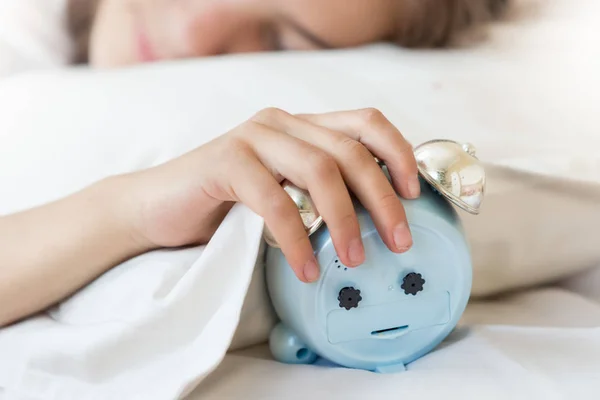 Nahaufnahme einer jungen Frau, die die Hand am Wecker hält — Stockfoto