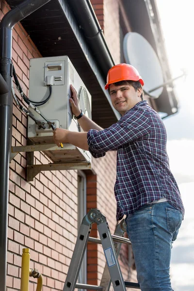 Técnico masculino reparando sistema de aire acondicionado al aire libre — Foto de Stock