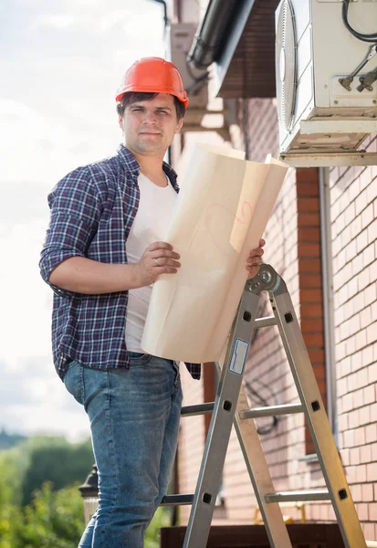 Engineer examining air conditioning system and comparing it with