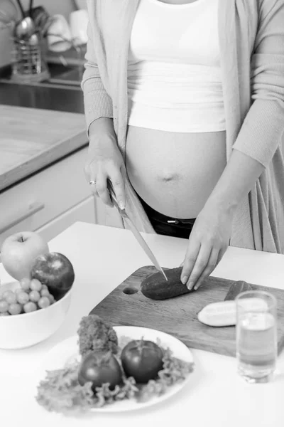 Foto de primer plano de la mujer embarazada haciendo ensalada de verduras en kitche — Foto de Stock