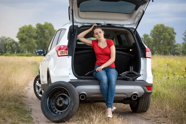 Mulher triste sentado em carro quebrado no campo — Fotografia de Stock