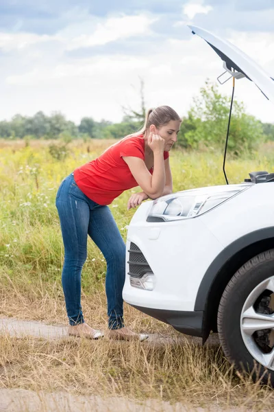 Joven mujer triste mirando el coche roto y esperando ayuda —  Fotos de Stock