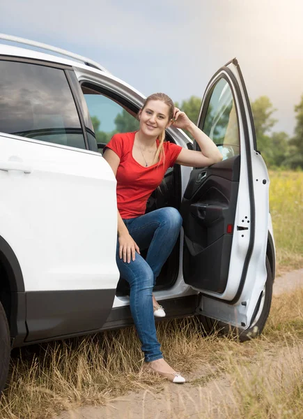 フィールドで車に座っている笑顔の女性 — ストック写真