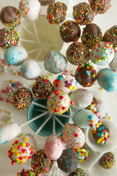 Toned top view shot of colorful cake pops against white wooden b — Stock Photo, Image