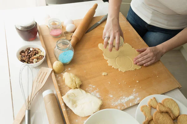 Closeup of young woman cutting dough with glass — Stock Photo, Image