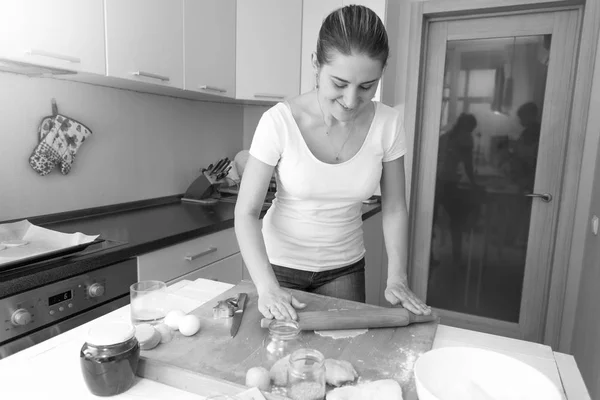 Чорно-біле зображення жінки, що робить тісто на кухні — стокове фото