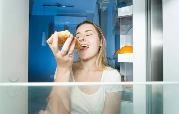 Portrait of beautiful woman eating pizza. View from inside of th — Stock Photo, Image