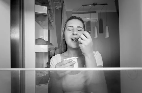 Genç kadın buzdolabına içinde siyah ve beyaz resim — Stok fotoğraf
