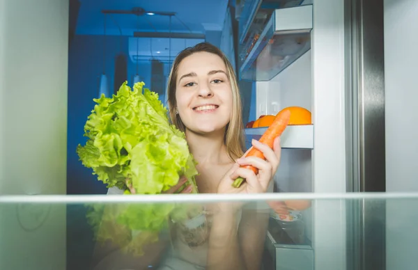 Retrato de mujer hermosa sosteniendo zanahoria y ensalada fresca —  Fotos de Stock