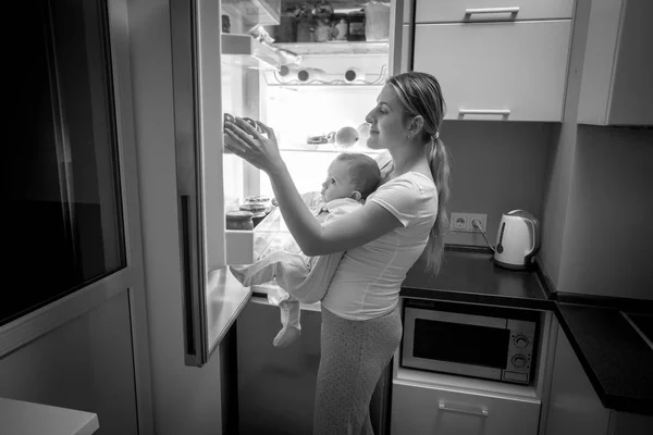 Black and white image of young mother and baby son looking insid — Stock Photo, Image