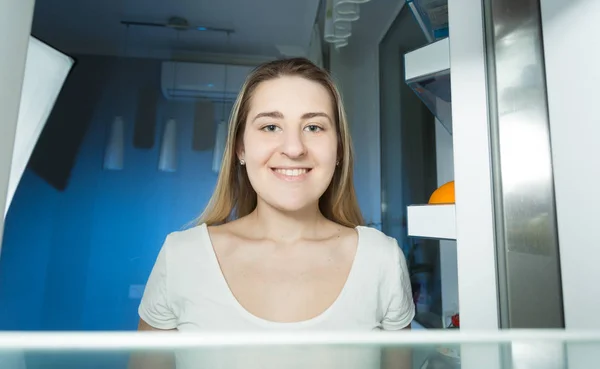 Frau im Schlafanzug schaut zu Hause spät in den Kühlschrank — Stockfoto