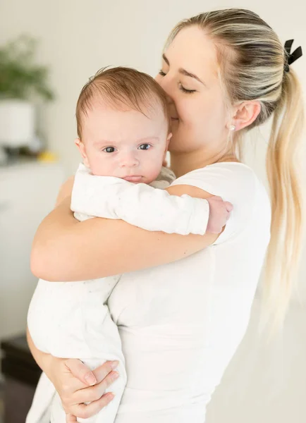 Young beautiful woman kissing her baby boy on hands — Stock Photo, Image