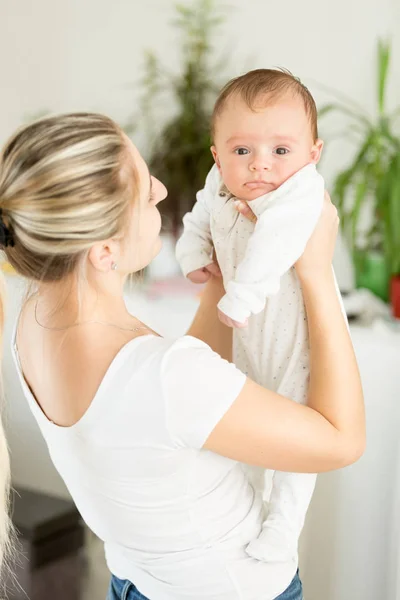 Portrait of smiling mother holding her baby boy — Stock Photo, Image