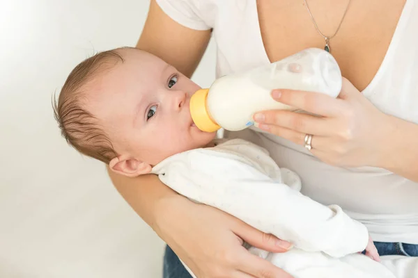 Onun erkek bebek tutan ve feedin genç anne closeup portresi — Stok fotoğraf