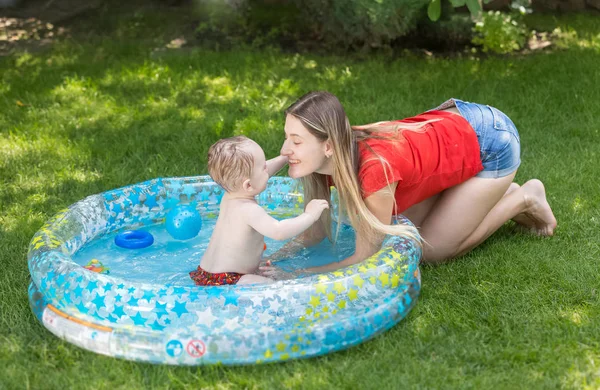 Bébé garçon dans la piscine extérieure jouant avec la mère — Photo