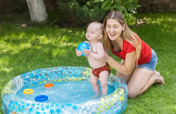 Junge Frau hat Spaß mit ihrem kleinen Jungen im Schwimmbad bei bac — Stockfoto