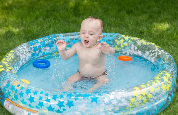 Chłopiec dziecko bawi się zabawkami w basenie w ogrodzie — Zdjęcie stockowe
