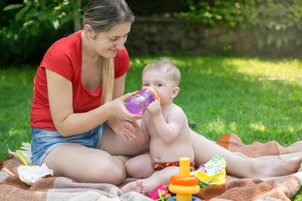 愛らしい赤ちゃんの少年は、ボトルから水を飲むのポートレート、クローズ アップ — ストック写真