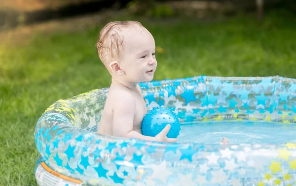 Niño de 9 meses jugando con la pelota en la piscina en el jardín — Foto de Stock