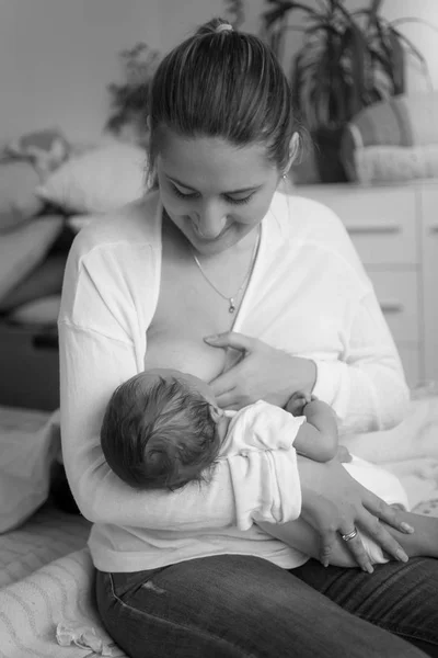 Preto e branco imagem de jovem mãe alimentação bebê com leite fro — Fotografia de Stock