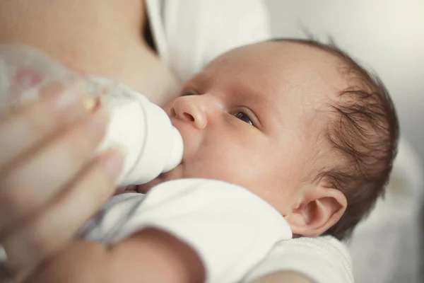 Nahaufnahme eines süßen Babys, das nach dem Milchessen auf den Händen der Mutter schläft — Stockfoto