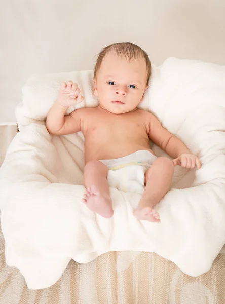 Bebê recém-nascido bonito com olhos azuis deitado na cesta — Fotografia de Stock