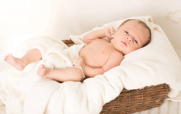 Portrait of beautiful baby boy lying in wicker basket — Stock Photo, Image