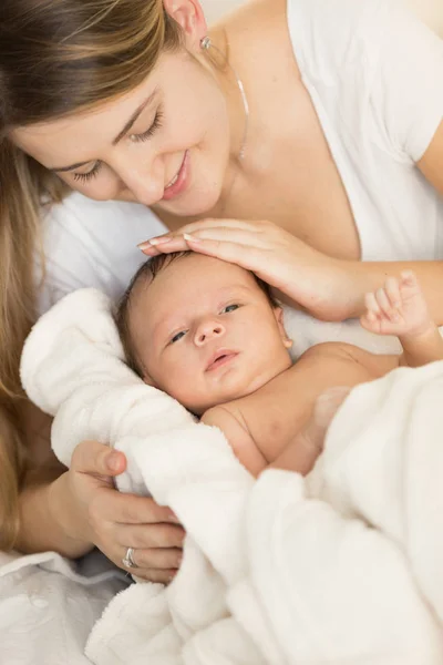 Closeup portrait of young caring mother hugging newborn baby on — Stock Photo, Image