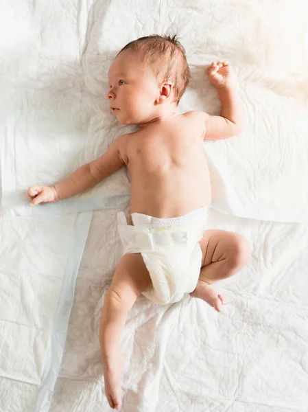 Retrato de bebé feliz sonriente acostado en la cama con sonajero — Foto de Stock