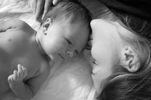 Preto e branco closeup retrato de jovem sorrindo mãe deitado w — Fotografia de Stock