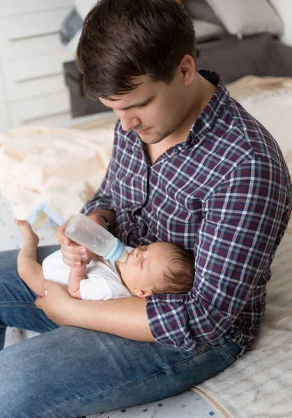 年轻的父亲用牛奶喂养刚出生的儿子的肖像 — 图库照片