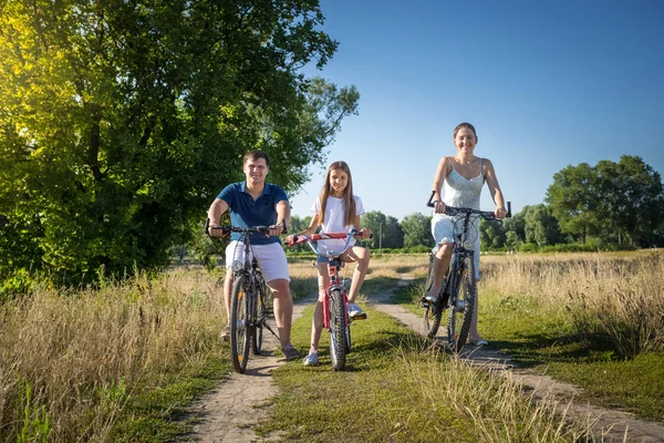 Familia feliz con hija teniendo fin de semana en sus bicicletas — Foto de Stock