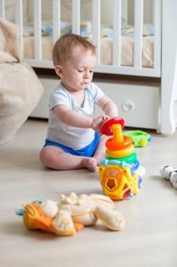 Sevimli çocuk, oturma odası katta renkli piramit montaj