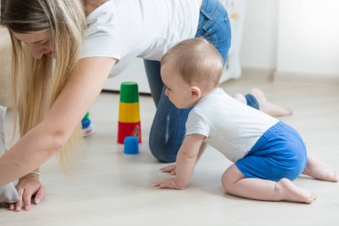 Yerde sürünen ve annesi ile oyuncak kule montaj erkek bebek